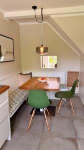 a dining room with a table and two green chairs at Haus SandRast in Westerland +5 photos
