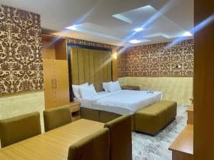 a hotel room with a bed and two chairs at Goldstep Hotel Effurun in Warri +14 photos