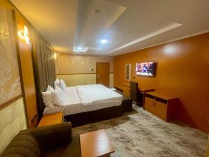a hotel room with a bed and a tv at Goldstep Hotel Effurun in Warri