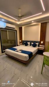 a bedroom with a large bed with blue pillows at Asusss International in New Digha
