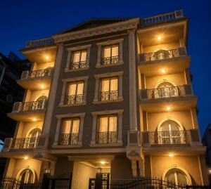 a tall building with windows and balconies at night at Roadhouse New Cairo Residence in Cairo