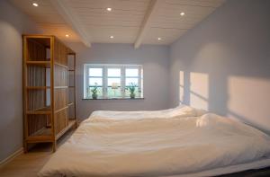 a bedroom with a white bed and a window at Almeboda in Österlen in Östra Hoby