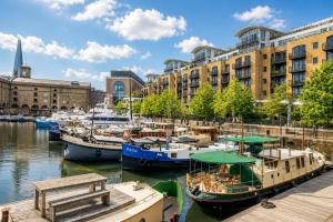 a group of boats docked in a harbor with buildings at Historic Dutch Barge, Idyllic location in London