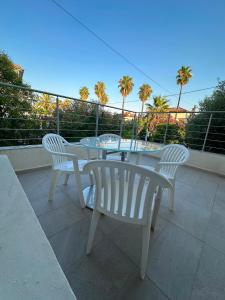 two white chairs and a table on a balcony at Charmante villa in Hyères