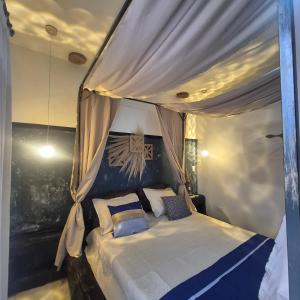 a bedroom with a canopy bed with blue pillows at Recanto Rustico Itapoá in Itapoa +208 photos
