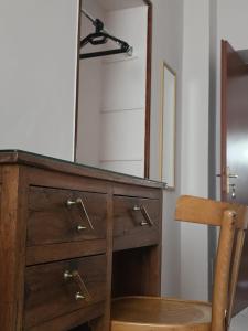 a wooden dresser with a mirror and a wooden chair at L'Angolo Rosa B&B in Piedimonte dʼAlife