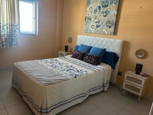 a bedroom with a large bed with blue pillows at Habitación con baño privado in Gáldar