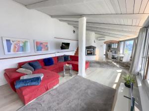 a living room with a red couch and a fireplace at Al Paradiso by Fewotessin in Ronco sopra Ascona