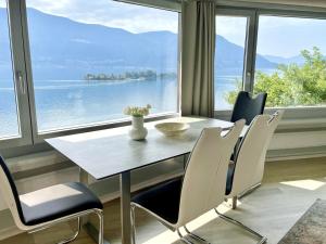 a dining room with a table and chairs and a large window at Al Paradiso by Fewotessin in Ronco sopra Ascona
