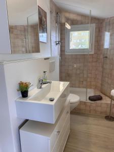 a white bathroom with a sink and a toilet at Al Paradiso by Fewotessin in Ronco sopra Ascona +17 photos