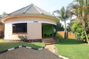 a small house with a green and white at Bavah Airport Hotel in Entebbe