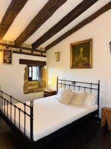 a bedroom with a bed and a painting on the wall at Museo de las Campanas, Vierna in San Bartolomé de Meruelo