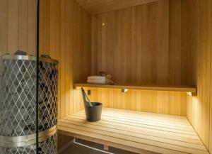 a sauna with a bucket sitting on a wooden shelf at City Choice Apartment in Helsinki