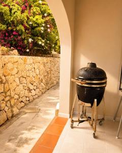 a large grill sitting on a stool next to a wall at Casa Toucan Moraira in Benitachell