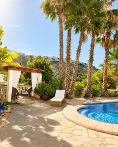 a patio with palm trees and a swimming pool at Casa Toucan Moraira in Benitachell