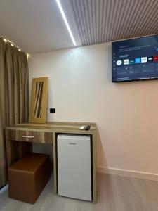 a room with a desk and a tv on the wall at Sidi's GuestHouse in Borsh