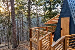 a cabin in the woods with a large wooden deck at Loblolly Pines Adventure Aframe #1 in Eureka Springs +21 photos