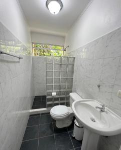 a bathroom with a toilet and a sink at Heliconia Island Lodge in Puerto Viejo
