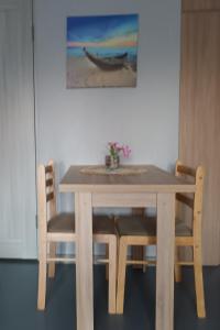 a wooden table with chairs and a picture of a boat at Idille Studio with Patio & Free Parking in Ventspils +6 photos