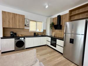a kitchen with a stainless steel refrigerator and wooden cabinets at Sky Residence House 5 in Cluj-Napoca