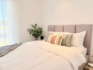 a bedroom with a large bed with white sheets and pillows at Sky Residence House 5 in Cluj-Napoca