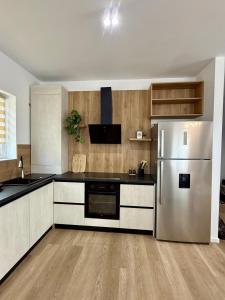 a kitchen with a stainless steel refrigerator and wooden cabinets at Sky Residence House 5 in Cluj-Napoca +10 photos
