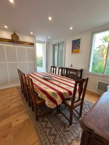 a dining room with a table with chairs and a tableablish at Charmante villa in Hyères
