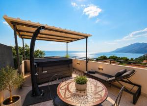 a patio with a grill and a table on a balcony at Apartman Štorija with Private Jacuzzi-Brela in Brela