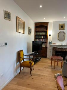 a living room with a television and a fireplace at Charmante villa in Hyères