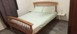 a bedroom with a wooden bed and a wooden chair at Nakhili in Keur Massar
