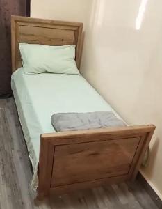 a bed with a wooden frame in a room at Nakhili in Keur Massar