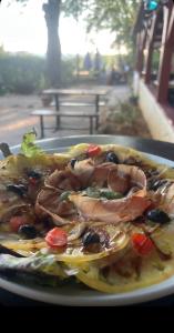 a plate of food with meat and vegetables on a table at N5 Emplacement tente van camping-car in Saint-Aubin-de-Nabirat
