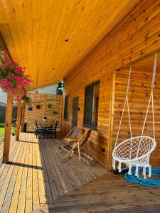 Veranda eines Holzhauses mit Schaukeln in der Unterkunft Cicha Przystań Skępe 300 m od jeziora in Skępe