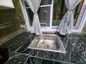 a sink in a counter with a window at The loft 2 in Ban Khlong Khwang Klang