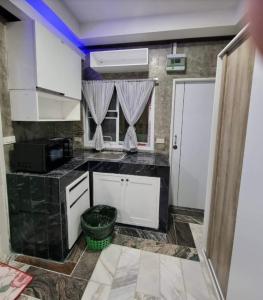 a kitchen with white cabinets and a black counter top at The loft 2 in Ban Khlong Khwang Klang