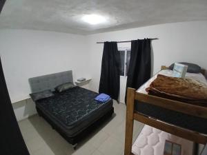 a bedroom with a bed and a chair in it at Hospedaje Cosquin in Cosquín