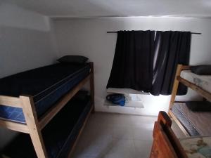 a small room with two bunk beds and a window at Hospedaje Cosquin in Cosquín +1 photo