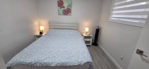 a bedroom with a bed with a blue comforter at La Rose des Prairies -The Prairie Rose in Calgary