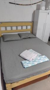 a bed with a wooden frame with a towel on it at Hostel Itapiru in Mateiros