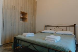 a bedroom with a bed with towels on it at Platanos View in Plátanos