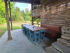 a wooden table and chairs and a couch on a patio at Kamp Kalavat in Vrtovac