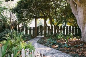 a fence in a garden with a walkway at Rock Rose Cottage in Trinidad