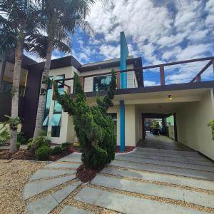 a house with palm trees in front of it at Recanto Rustico Itapoá in Itapoa