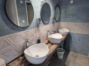 a bathroom with two sinks and two mirrors at Kamp Kalavat in Vrtovac