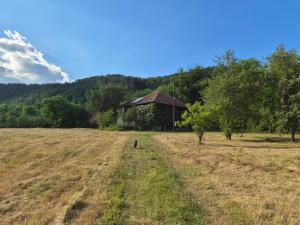 an open field with a barn in the background at Kamp Kalavat in Vrtovac