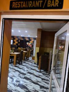 a restaurant with tables and chairs and a restaurant bar at Goldstep Hotel Effurun in Warri