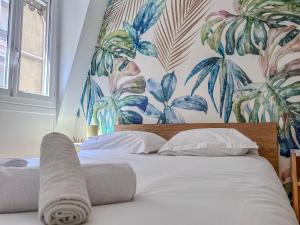 a bedroom with a bed with a tropical wallpaper at Le Grand Sault - Hyper-Centre in Grenoble +13 photos