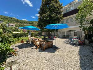 a patio with tables and umbrellas in front of a building at LaRos Apt in Herceg-Novi
