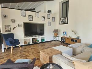 a living room with a large flat screen tv at Joli cocon familial in Neuilly-Saint-Front