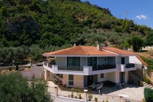a large house with a mountain in the background at Platanos View in Plátanos